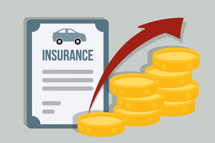 Coins stacked in front of car insurance policy showing rising cost over time or premium rate increase at policy renewal